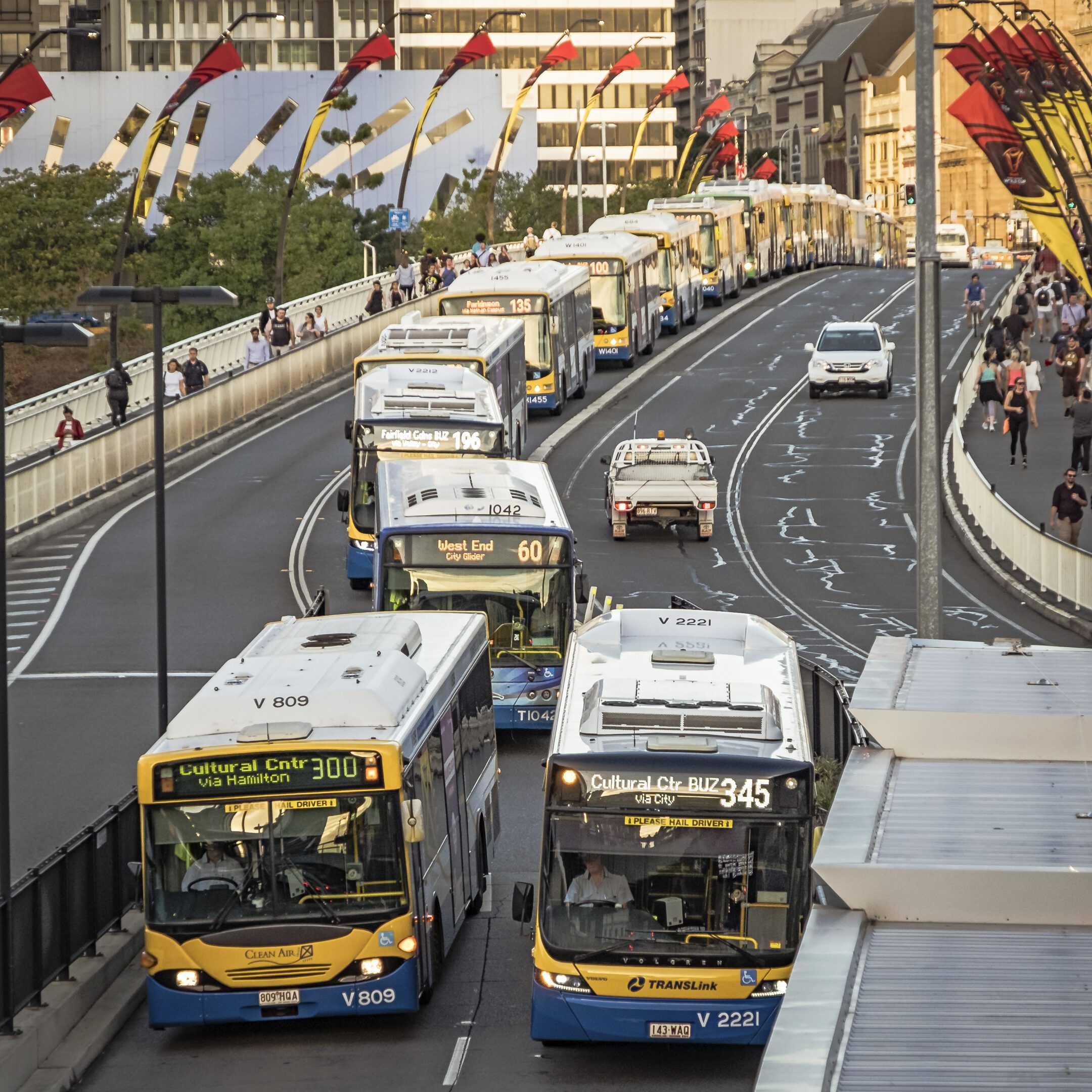 Buses and cars on a busy bridge.