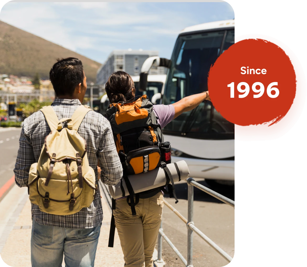 Two backpackers near buses, "Since 1996.