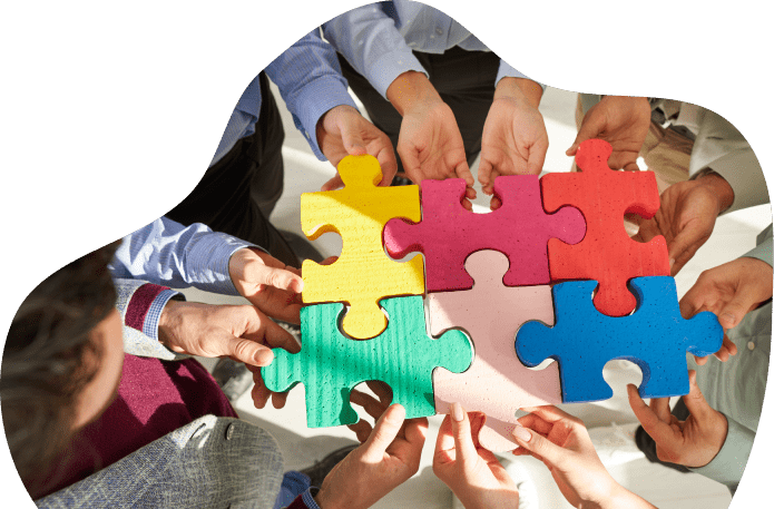 Hands holding colorful puzzle pieces together.
