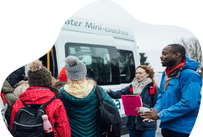 Group gathered near a parked mini-coach.